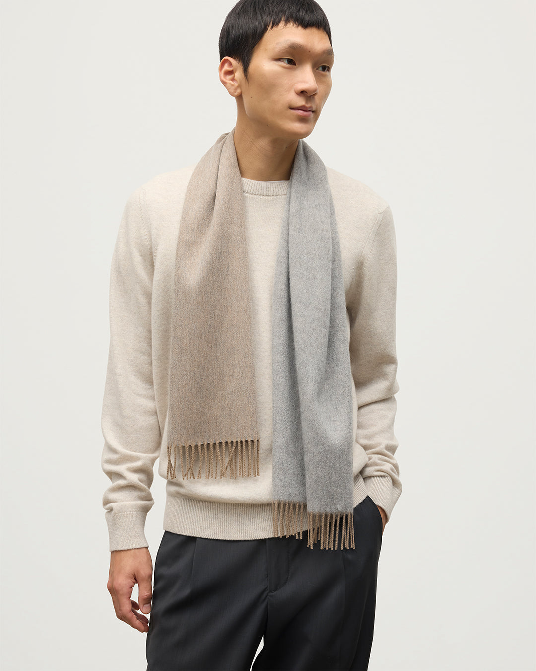 MALE MODEL WEARS JOHNSTONS OF ELGIN NATURAL BARD SCARF 100% CASHMERE OVER A NATURAL CASHMERE SWEATER WA002560RU7726ONE