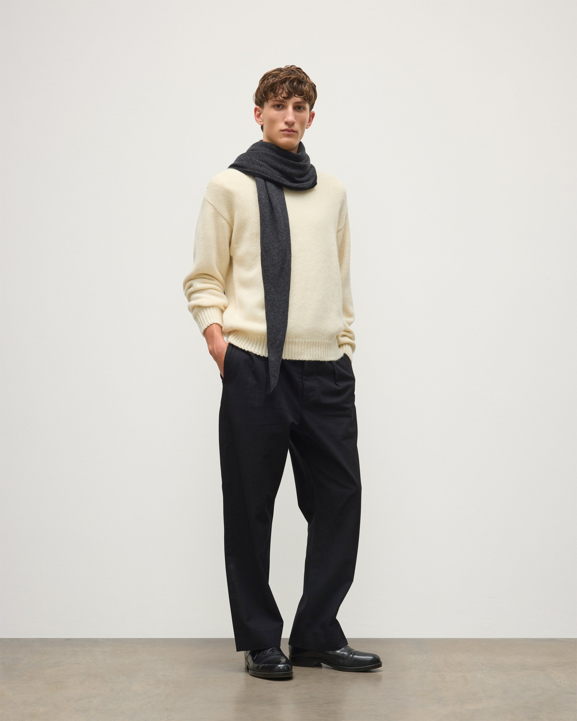 MALE MODEL WEARING JOHNSTONS OF ELGIN CASHMERE GAUZY ETHEL DIAMOND SCARF BLACK & GREY 100% CASHMERE OVER CREAM CASHMERE SWEATER HAE03401Q26237ONE