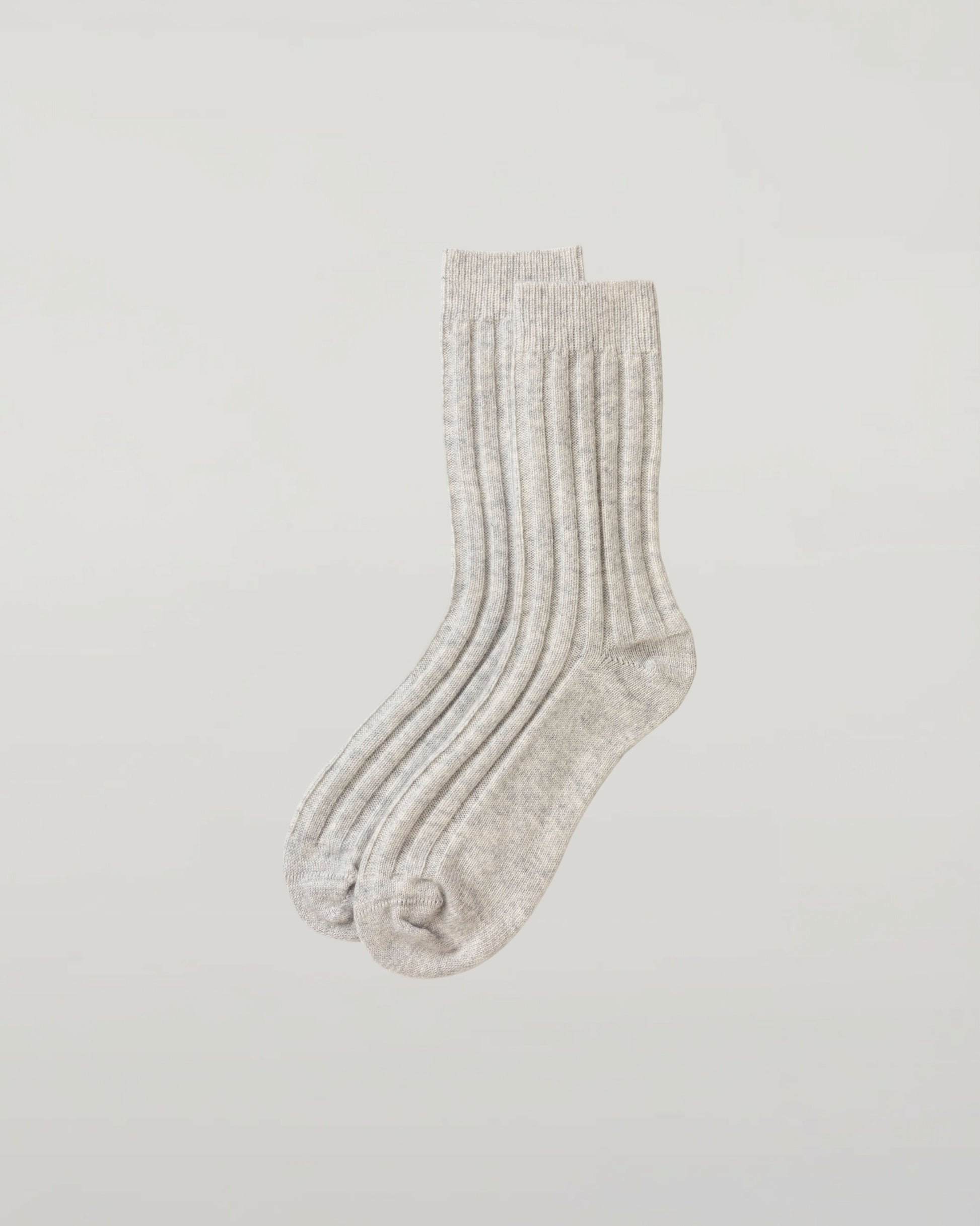 Johnstons of Elgin set of three pairs of cashmere socks in navy, light grey, and mid grey on a light grey background 2025GIFTSET4A