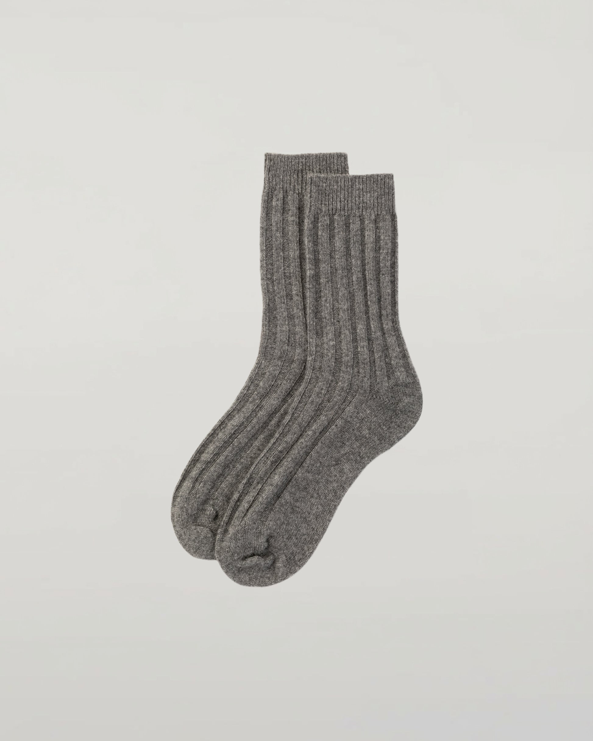 Johnstons of Elgin set of three pairs of cashmere socks in navy, light grey, and mid grey on a light grey background 2025GIFTSET4A
