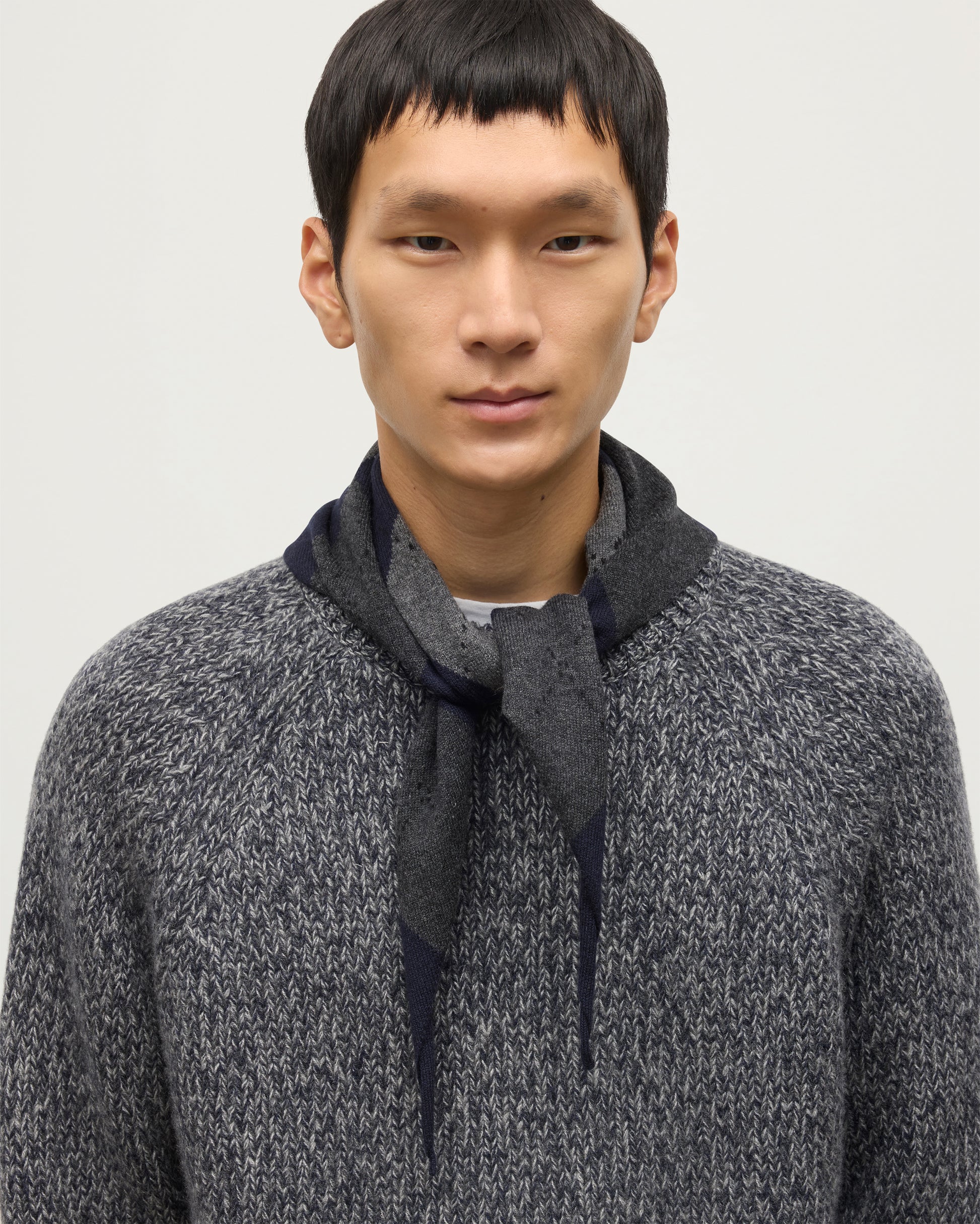 JOHNSTONS OF ELGIN CLAN BANDANA NAVY 100% CASHMERE ON A MALE MODEL OVER A NAVY MARL CASHMERE SWEATER HAP03612JU1613ONE
