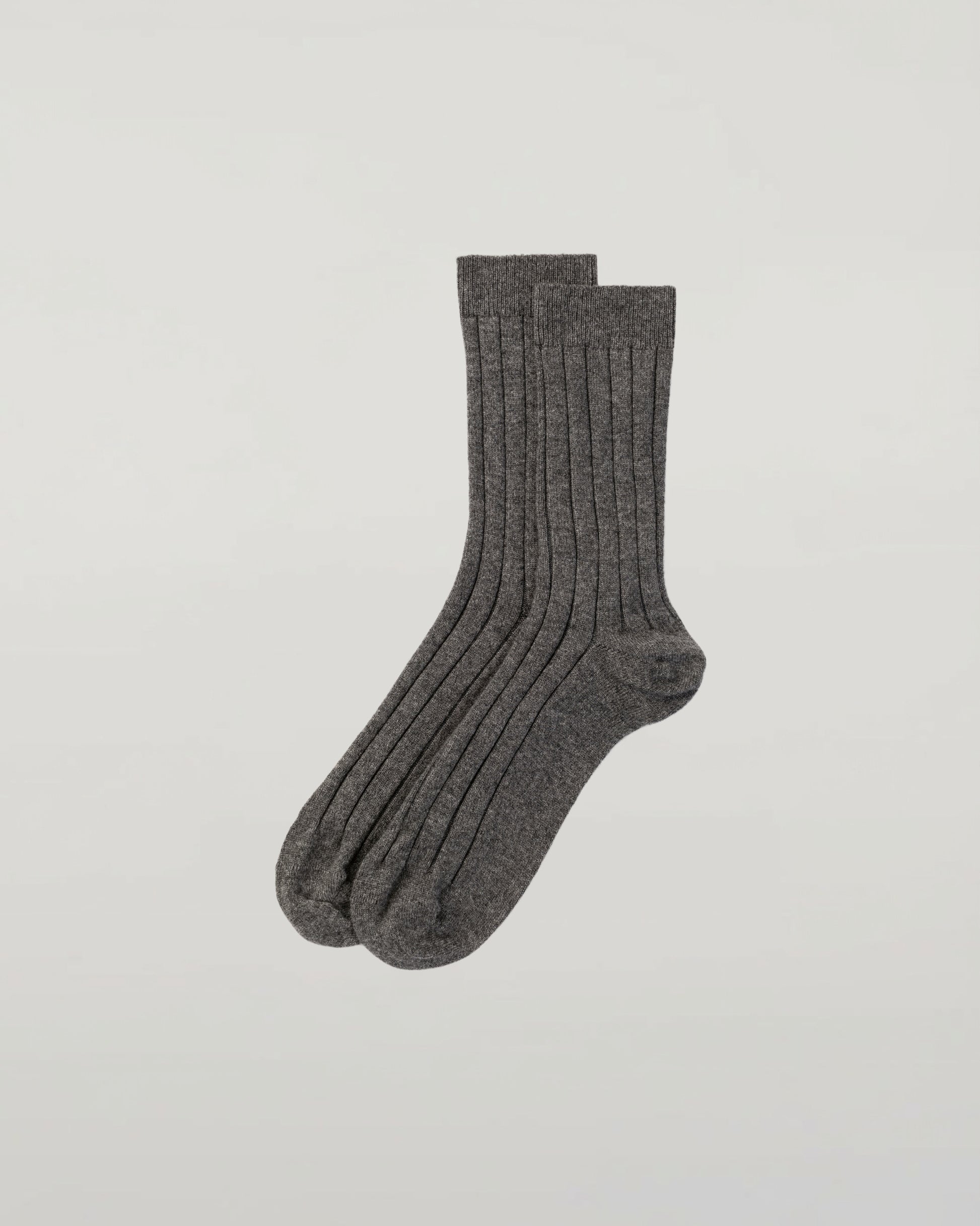 Johnstons of Elgin set of three pairs of cashmere socks in grey, navy, and beige on a light grey background 2025GIFTSET2