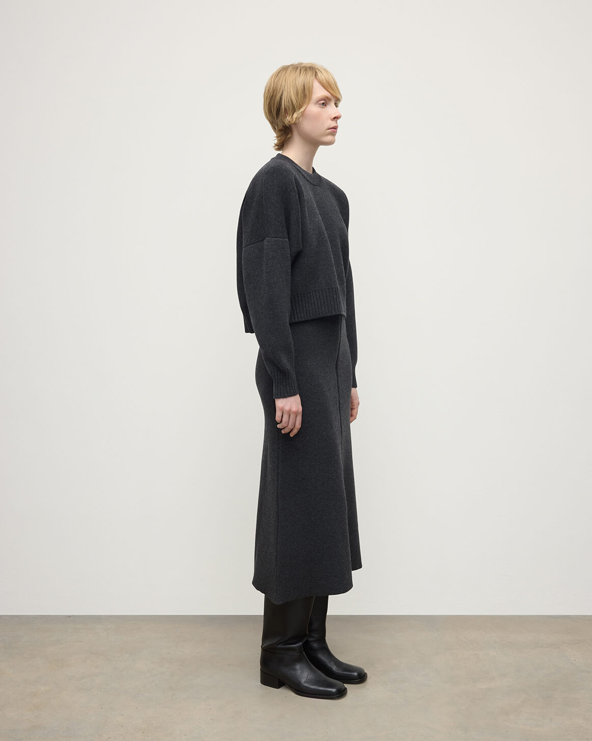 Model wearing Johnstons of Elgin AW25 Women's Knitwear Charcoal A-Line Milano Grey Cashmere Skirt Side View KAA05600HA7165