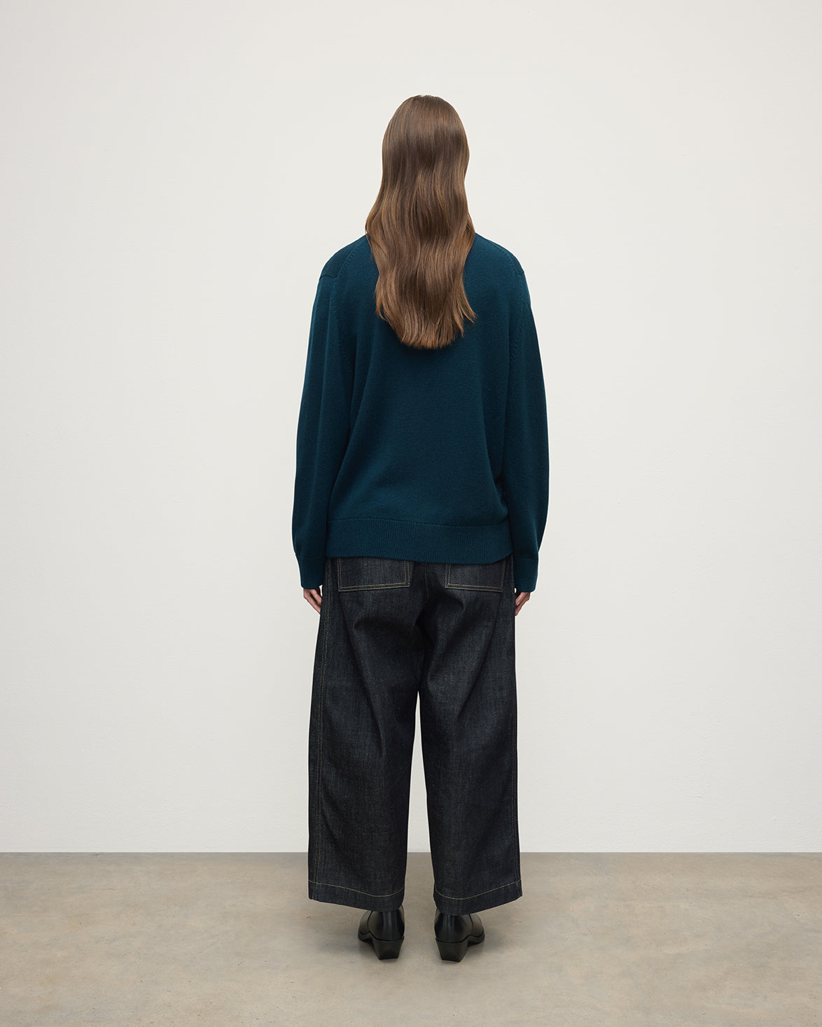 Model wears Johnstons of Elgin AW25 Women's Knitwear Bottle Green Boyfriend-Fit Green Cashmere Cardigan  Back View KAA05560SC7341
