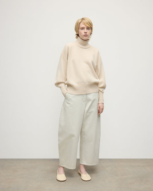 Model wearing Johnstons of Elgin AW25 Women's Knitwear Champagne High Neck Cream Cashmere Jumper Front View  KAA05585SA0502