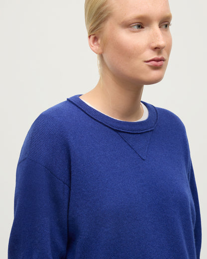 MODEL WEARING JOHNSTONS OF ELGIN WOMENS STELLA SWEATSHIRT BLUE 100% CASHMERE OVER A WHITE T_SHIRT KAA05770SD5326