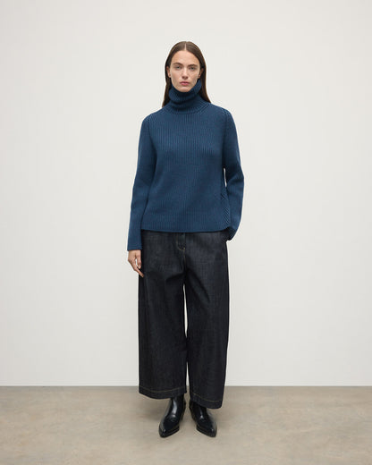 Model wears Johnstons of Elgin AW25 Women's Knitwear Heather Navy Roll-Collar Navy Cashmere Jumper Front View KAB05492HD7321