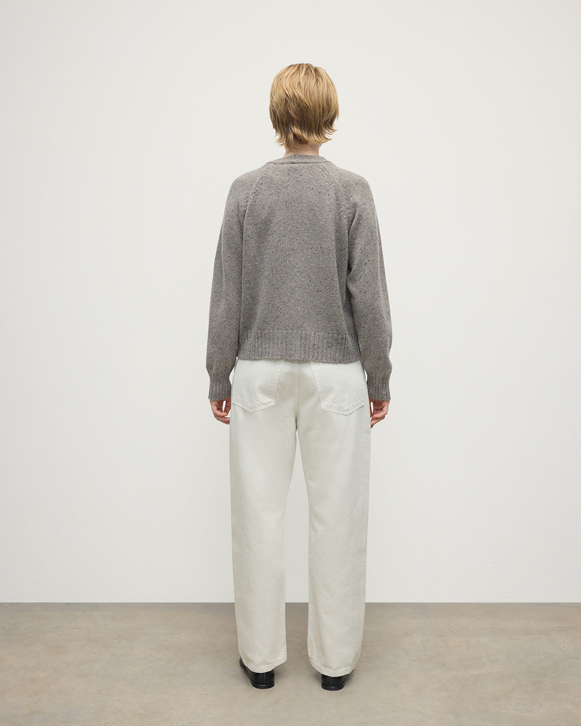 Model wearing Johnstons of Elgin AW25 Women's Knitwear Peregrine Donegal Donegal Cashmere Grey V Neck Cardigan Back View KAC05090006335