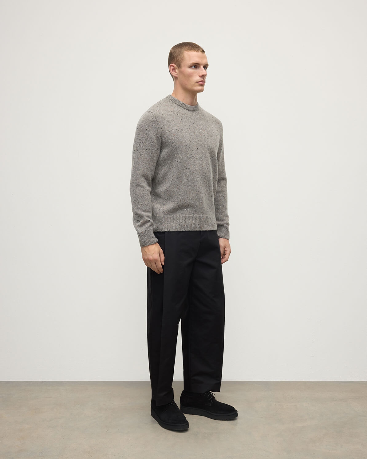 Model wearing Johnstons of Elgin AW25 Men's Knitwear Peregrine Donegal Grey Donegal Cashmere Marl Jumper Side KAC05287006335