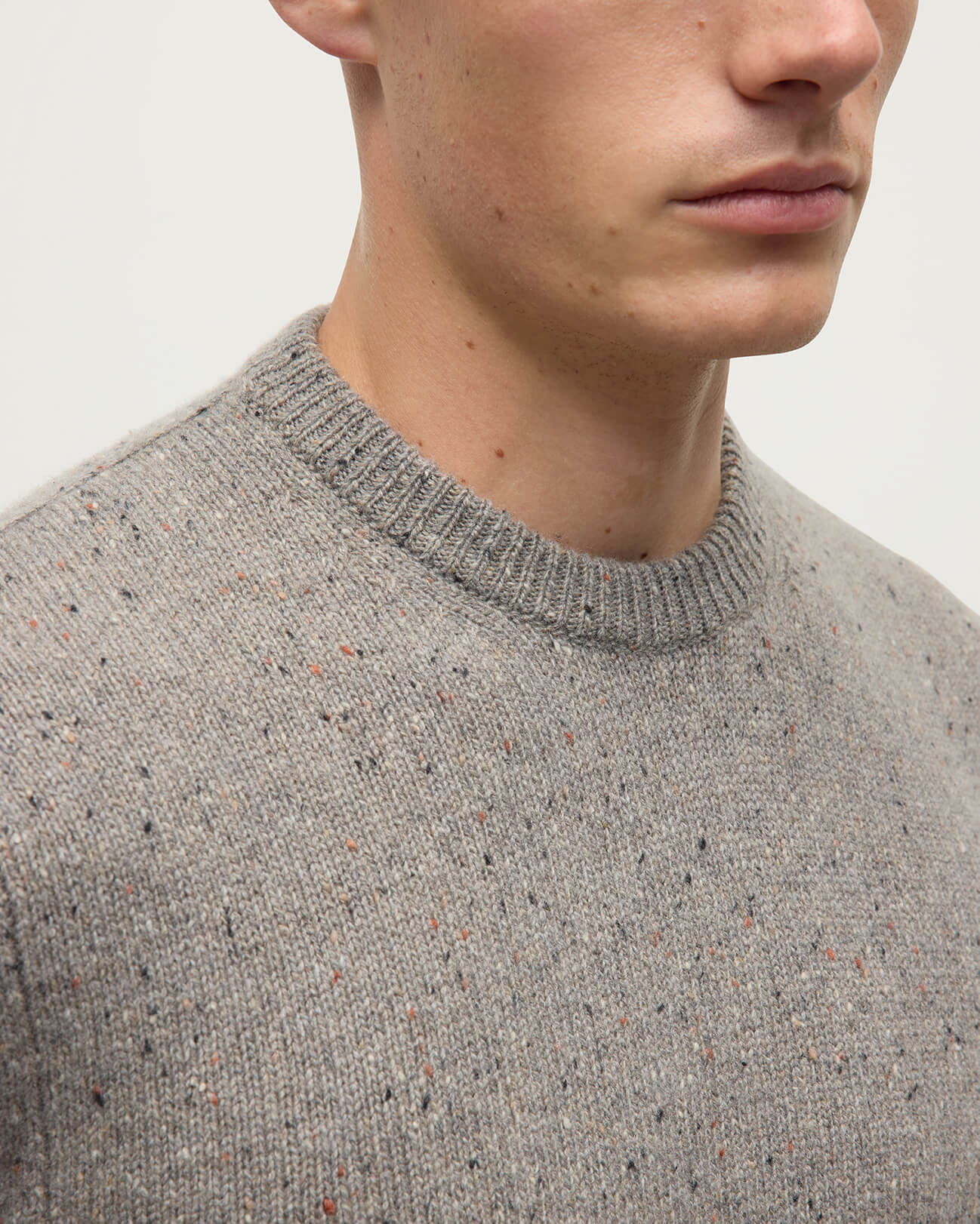 Model wearing Johnstons of Elgin AW25 Men's Knitwear Peregrine Donegal Grey Donegal Cashmere Marl Jumper Details KAC05287006335