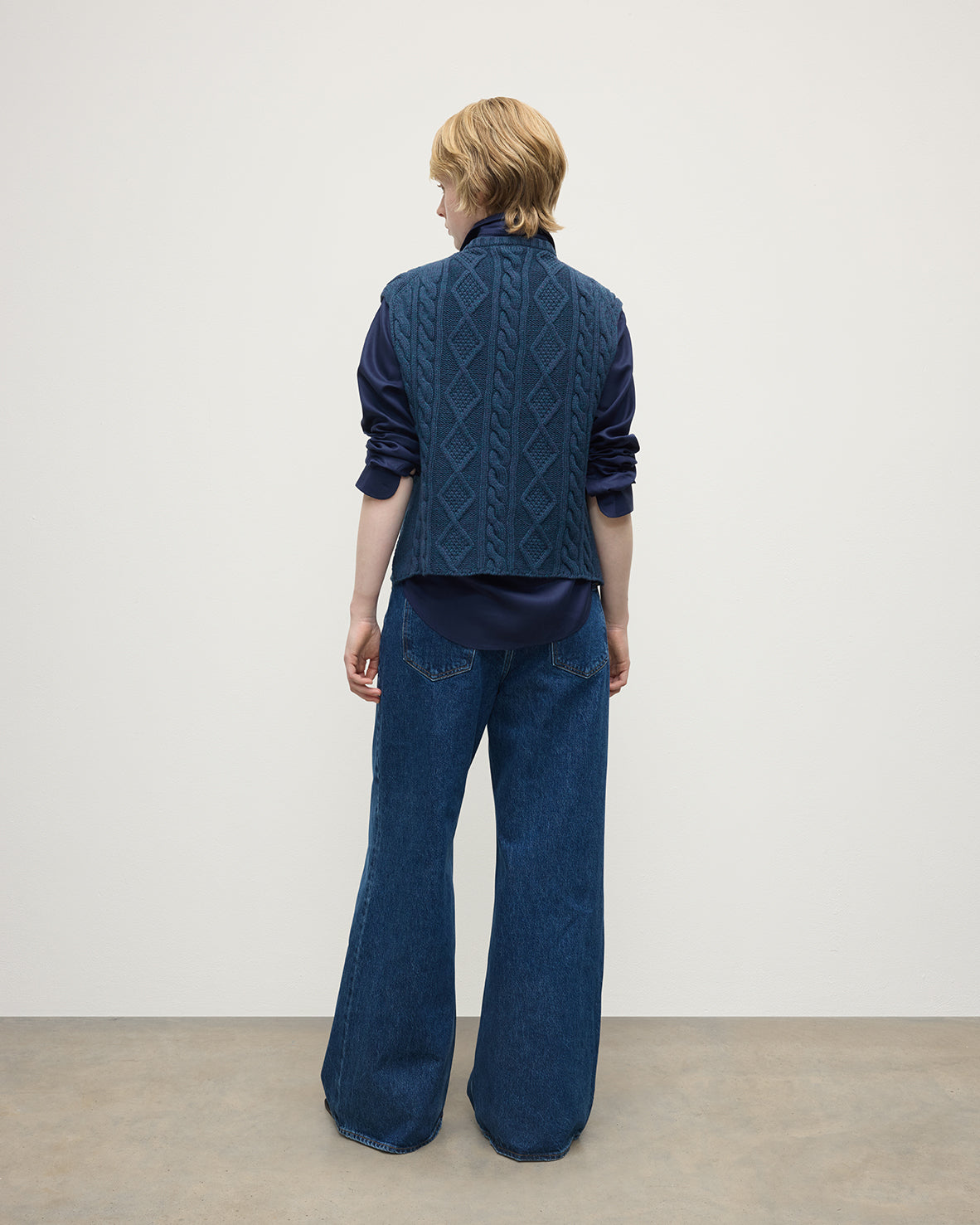 Model wears Johnstons of Elgin AW25 Women's Knitwear Heather Navy Aran Cable Navy Cashmere Tank Back View KAC05321HD7321