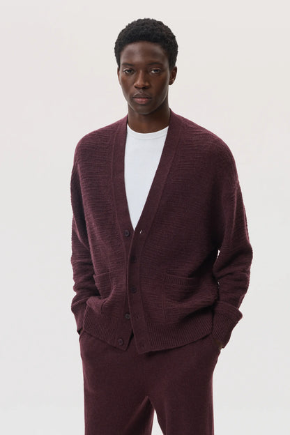 Male model wearing Johnstons of Elgin SS25 Unisex Knitwear Rosewood Textured Cashmere Cardigan with superfine cashmere sweater in white, and rosewood cashmere jogger  KAC05415SB7089