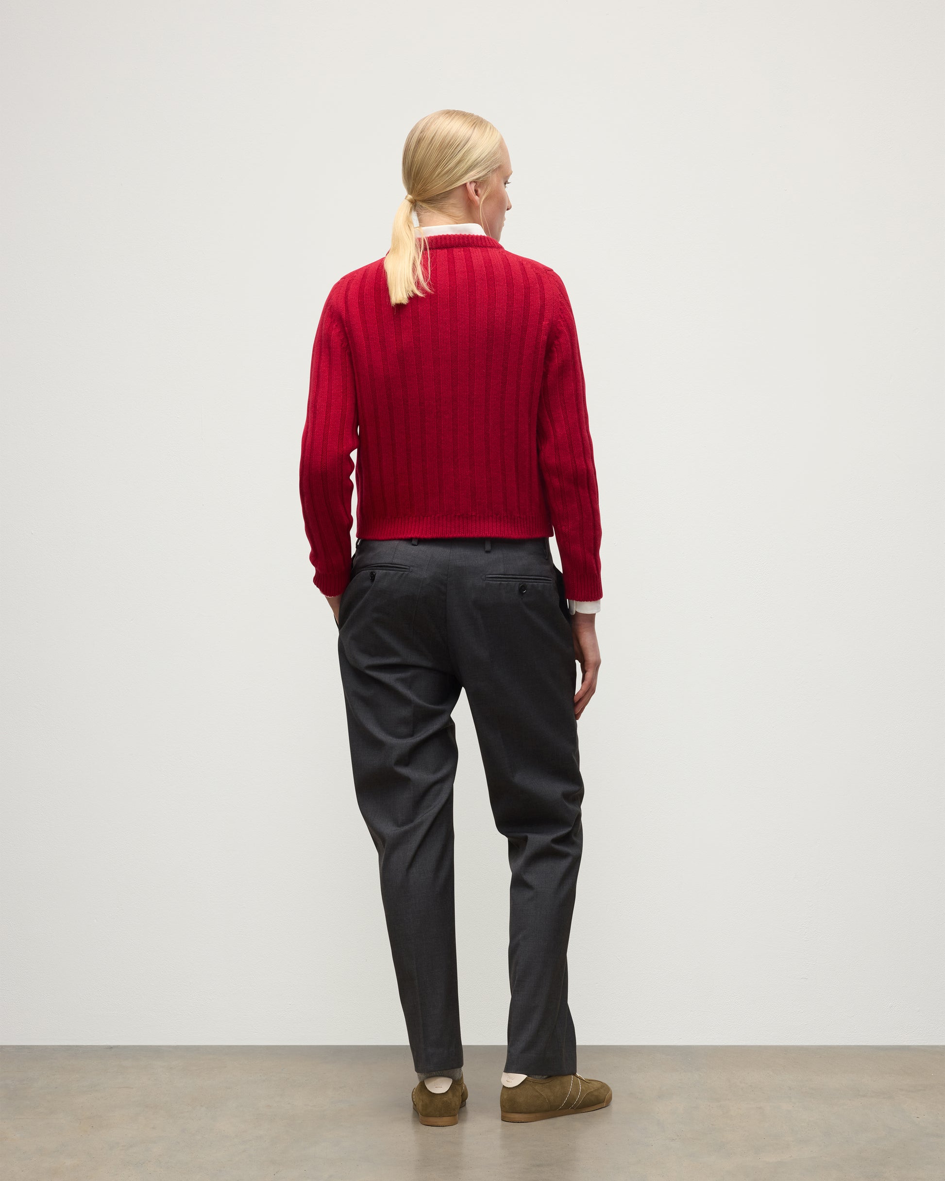 BACK OF MODEL WEARING JOHNSTONS OF ELGIN WOMENS LECHT CREW SWEATER RED OVER WHITE SHIRT WITH GREY TROUSERS ANDTRAINERS  KAC05706SE5325