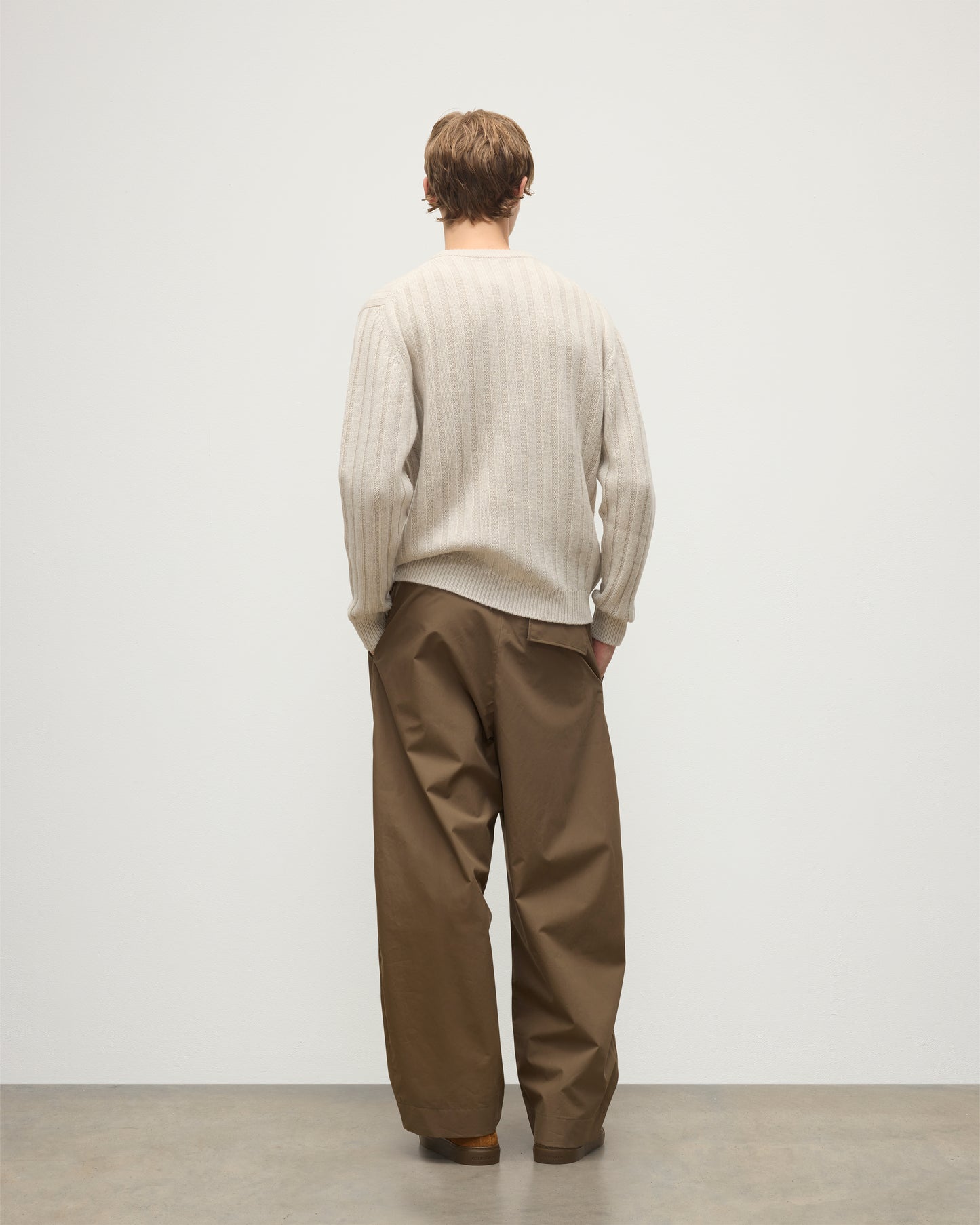 JOHNSTONS OF ELGIN MENS PEEL CREW SWEATER NATURAL 100% CASHMERE ON A MODEL OVER A WHITE T-SHIRT WITH BROWN TROUSERS KAC05751HA0402
