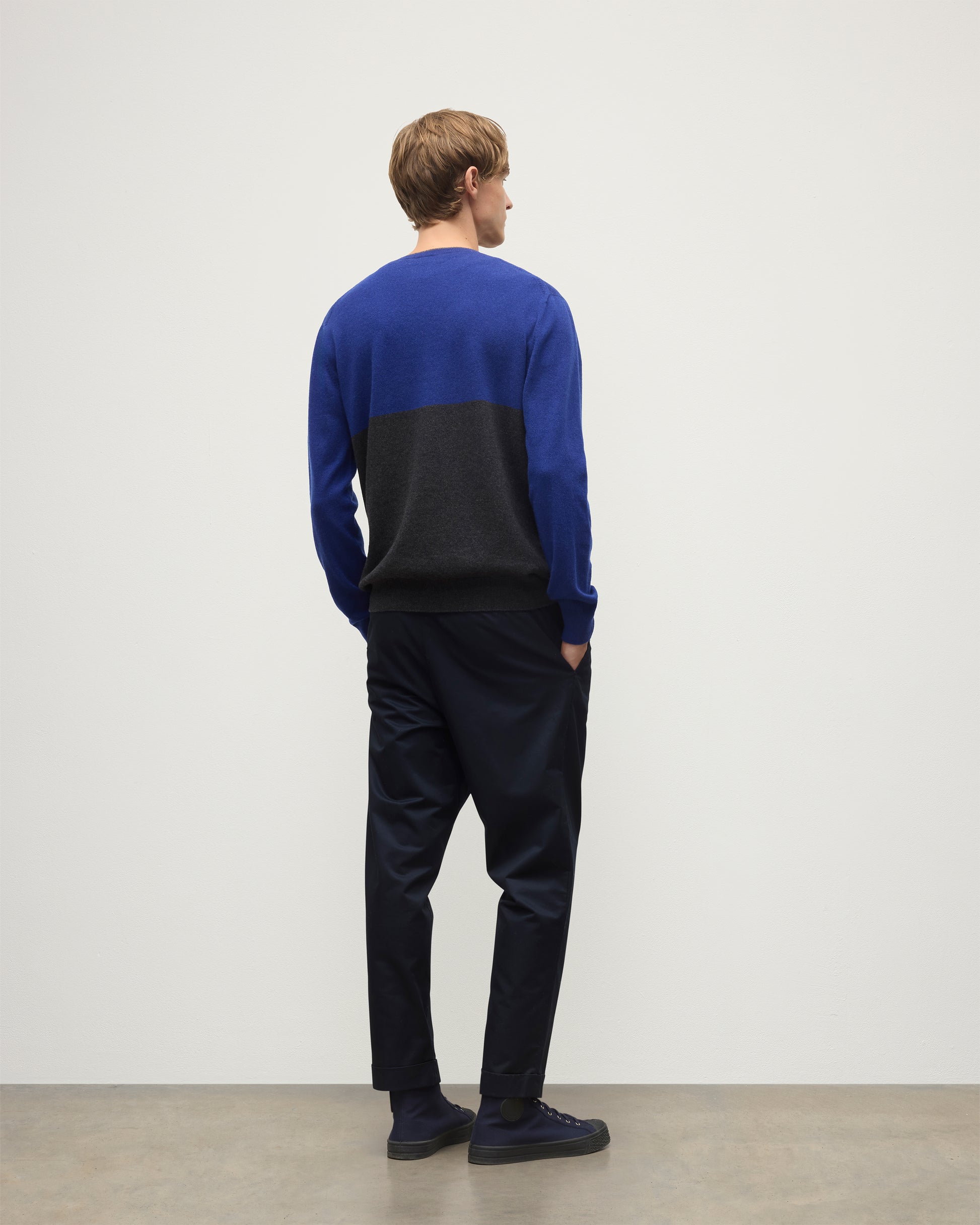 MODEL WEARING JOHNSTONS OF ELGIN MENS SHADED CREW SWEATER GREY 100% CASHMERE OVER A WHITE  T-SHIRT WITH NAVY TROUSERS KAI05232Q25945