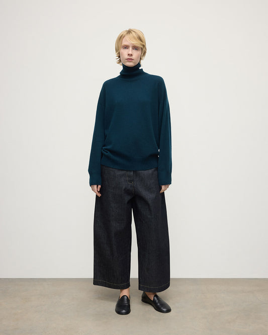 Model wears Johnstons of Elgin AW25 Women's Knitwear Bottle Green Gauzy Cashmere Green Roll Neck Jumper Front View KAI05324SC7341