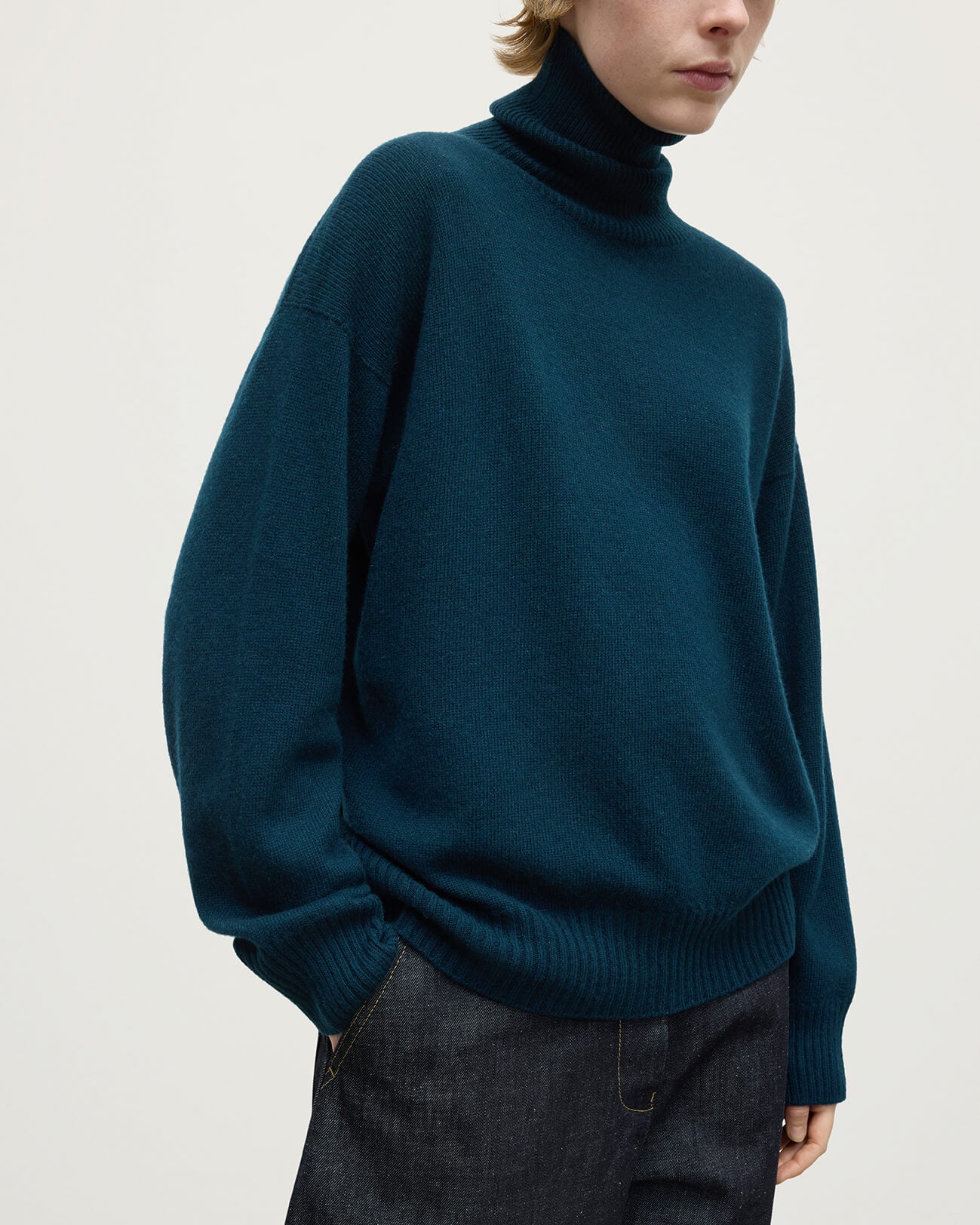 Model wears Johnstons of Elgin AW25 Women's Knitwear Bottle Green Gauzy Cashmere Green Roll Neck Jumper Details KAI05324SC7341