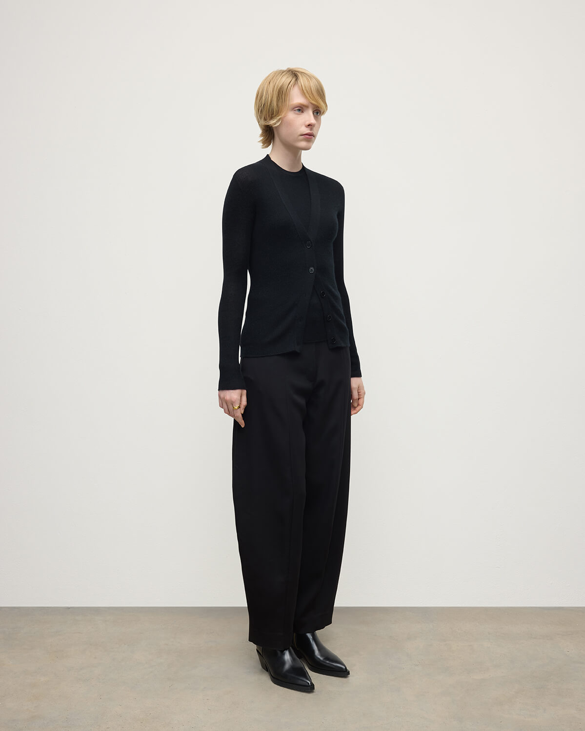 Model wears Johnstons of Elgin AW25 Women's Knitwear Black Superfine Cashmere Black Cardigan Side View KAI05372SA7146