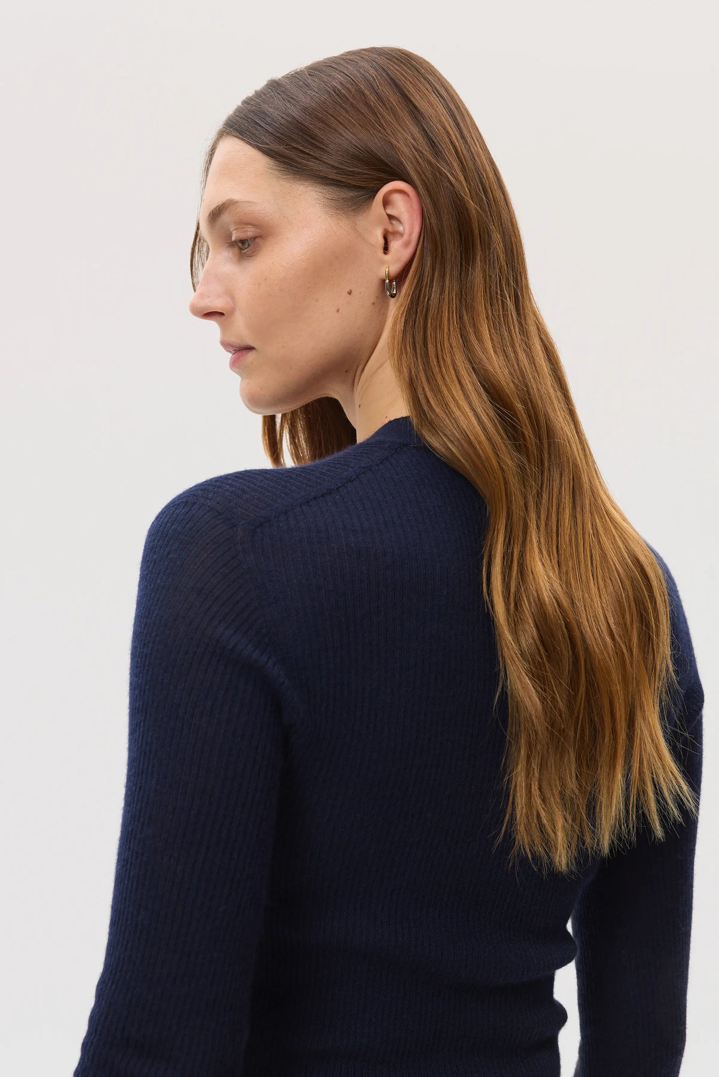 Model wearing Johnstons of Elgin SS25 Women's Knitwear Navy Superfine Cashmere Ribbed Cardigan on a white backdrop KAI05372SD7600