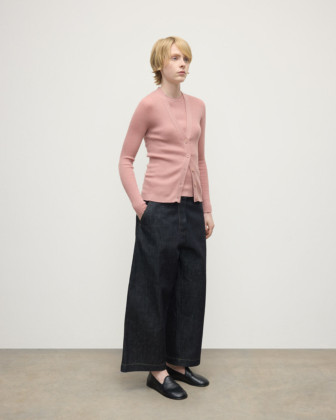 Model wears Johnstons of Elgin AW25 Women's Knitwear Nude Superfine Cashmere Pink Cardigan Side View KAI05372SE5274