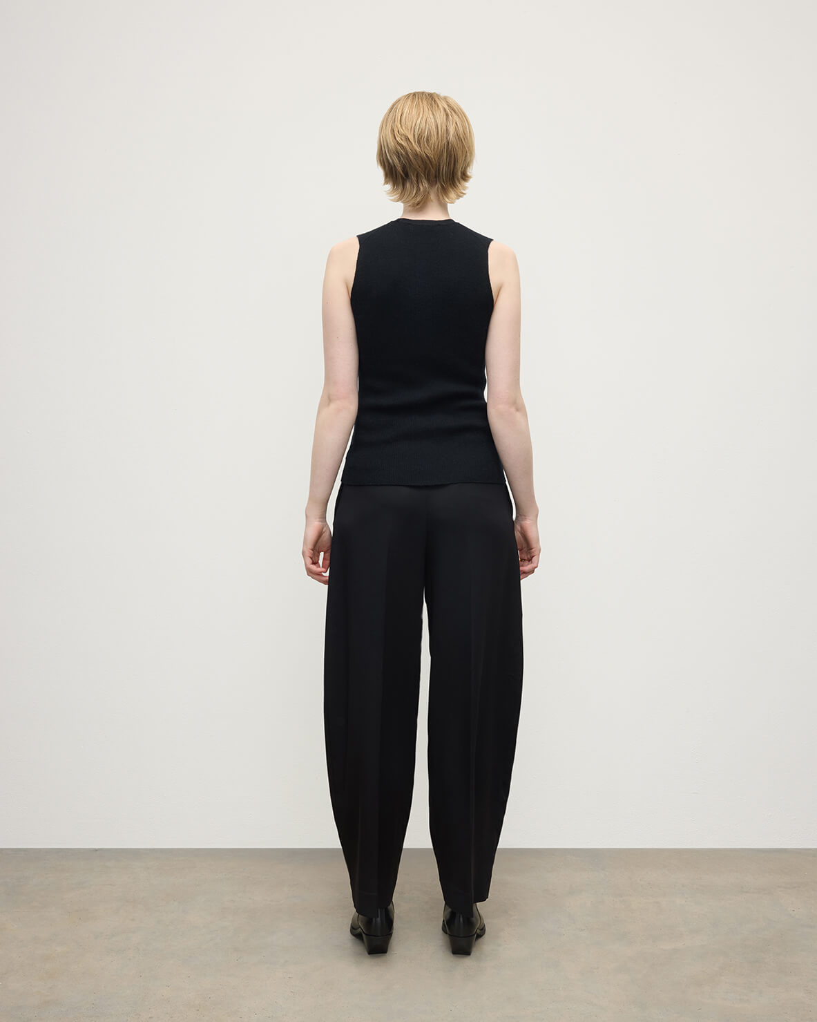 model wears Johnstons of Elgin AW25 Women's Knitwear Black Sleeveless Black Tank Top back view KAI05559SA7146