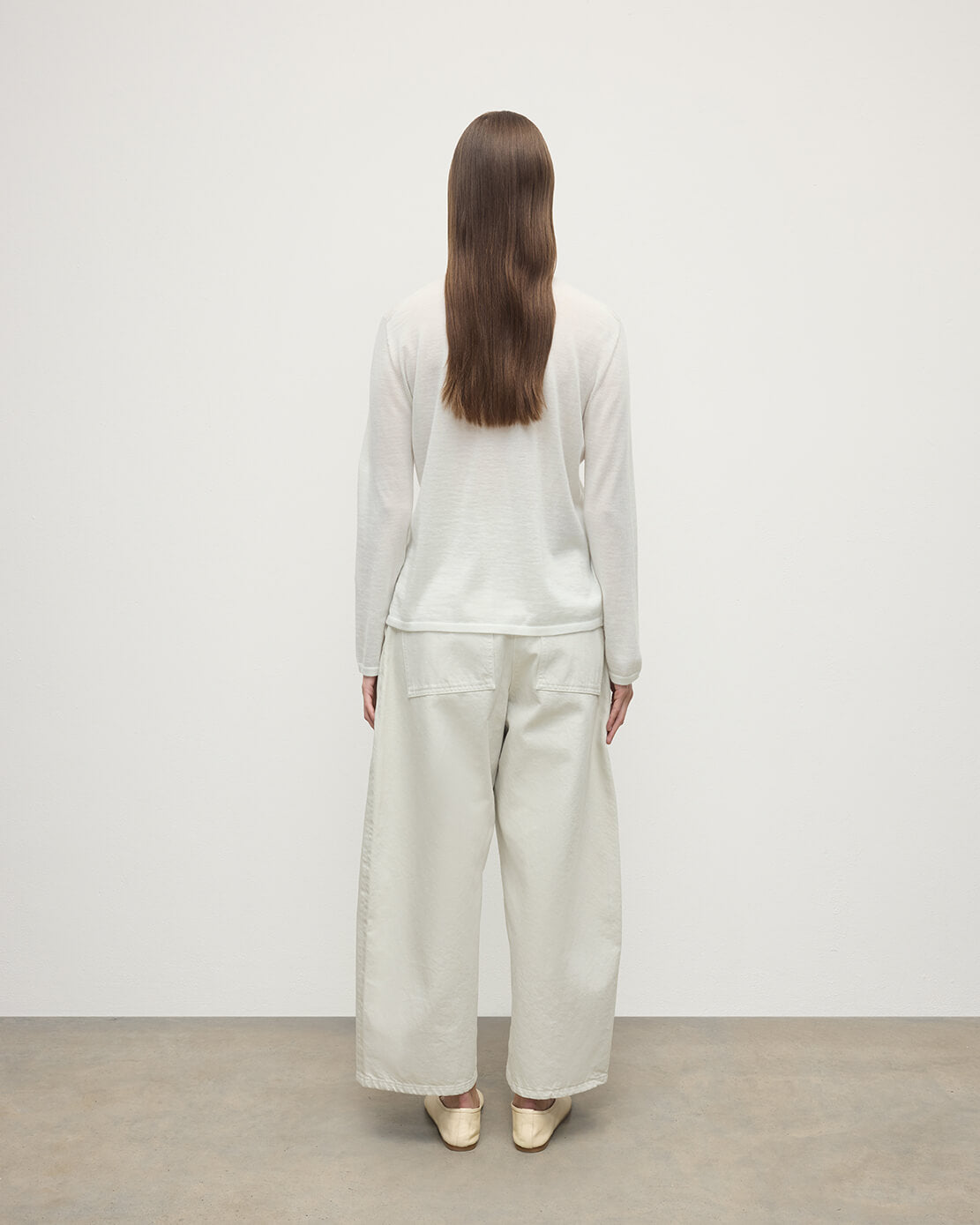 Model wearing Johnstons of Elgin AW25 Women's Knitwear Zinc White Superfine Cashmere White Roll Neck Jumper Back View  KAI05607HA0327