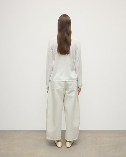 Model wearing Johnstons of Elgin AW25 Women's Knitwear Zinc White Superfine Cashmere White Roll Neck Jumper Back View  KAI05607HA0327