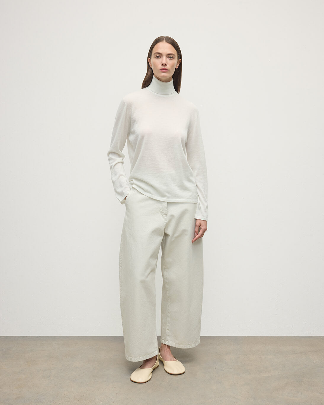 Model wearing Johnstons of Elgin AW25 Women's Knitwear Zinc White Superfine Cashmere White Roll Neck Jumper Front View  KAI05607HA0327