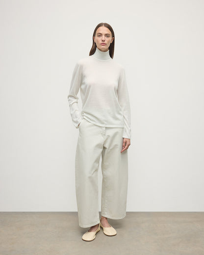 Model wearing Johnstons of Elgin AW25 Women's Knitwear Zinc White Superfine Cashmere White Roll Neck Jumper Front View  KAI05607HA0327