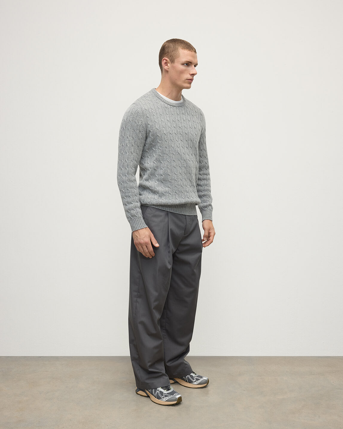 Model wears Johnstons of Elgin AW25 Men's Knitwear Light Grey Cable Knit Grey Cashmere Jumper Side KAI05693HA0308