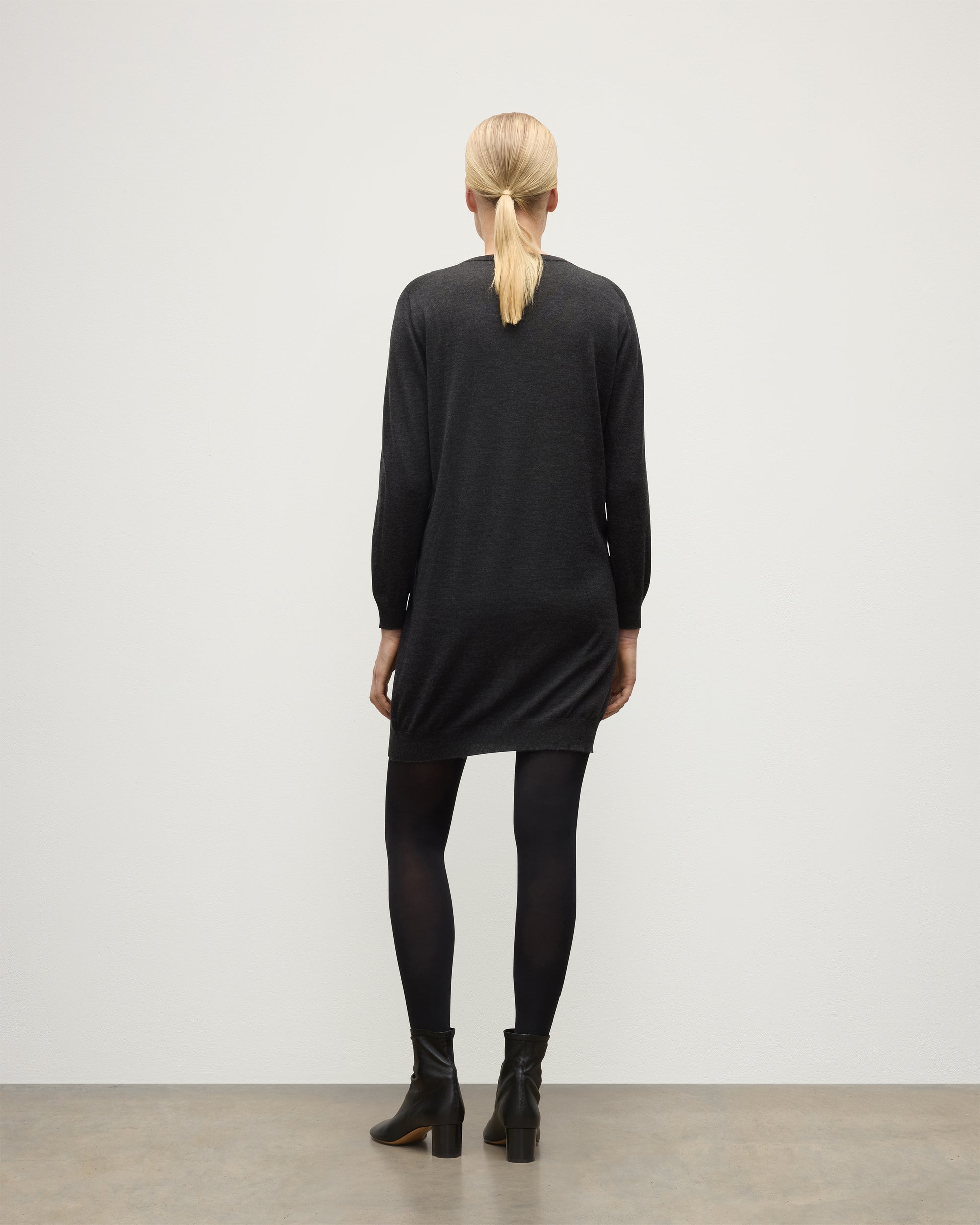 MODEL WEARING JOHNSTONS OF ELGIN WOMENS ELISE VEE SWEATER GREY 100% SUPERFINE CASHMERE WITH BLACK TIGHTS AND BOOTS KAI05715HA7218