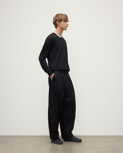 MODEL WEARS JOHNSTONS OF ELGIN MENS FIN SUPERFINE CREW BLACK 100% SUPERFINE CASHMERE OVER A WHITE T-SHIRT WITH BLACK TROUSERS KAI05717SA7146