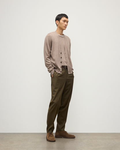 MALE MODEL WEARING JOHNSTONS OF ELGIN FORSYTH SUPERFINE VEE NECK CARDIGAN LIGHT BROWN  OVER A MATCHING SUPERFINE CASHMERE SWEATER AND OLIVE TROUSERS KAI05740HB0273