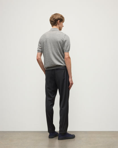 MODEL WEARS JOHNSTONS OF ELGIN MENS FIN SHORT SLEEVE SUPERFINE POLOSHIRT GREY OVER A WHITE T-SHIRT WITH NAVY TROUSERS KAI05741HA4253