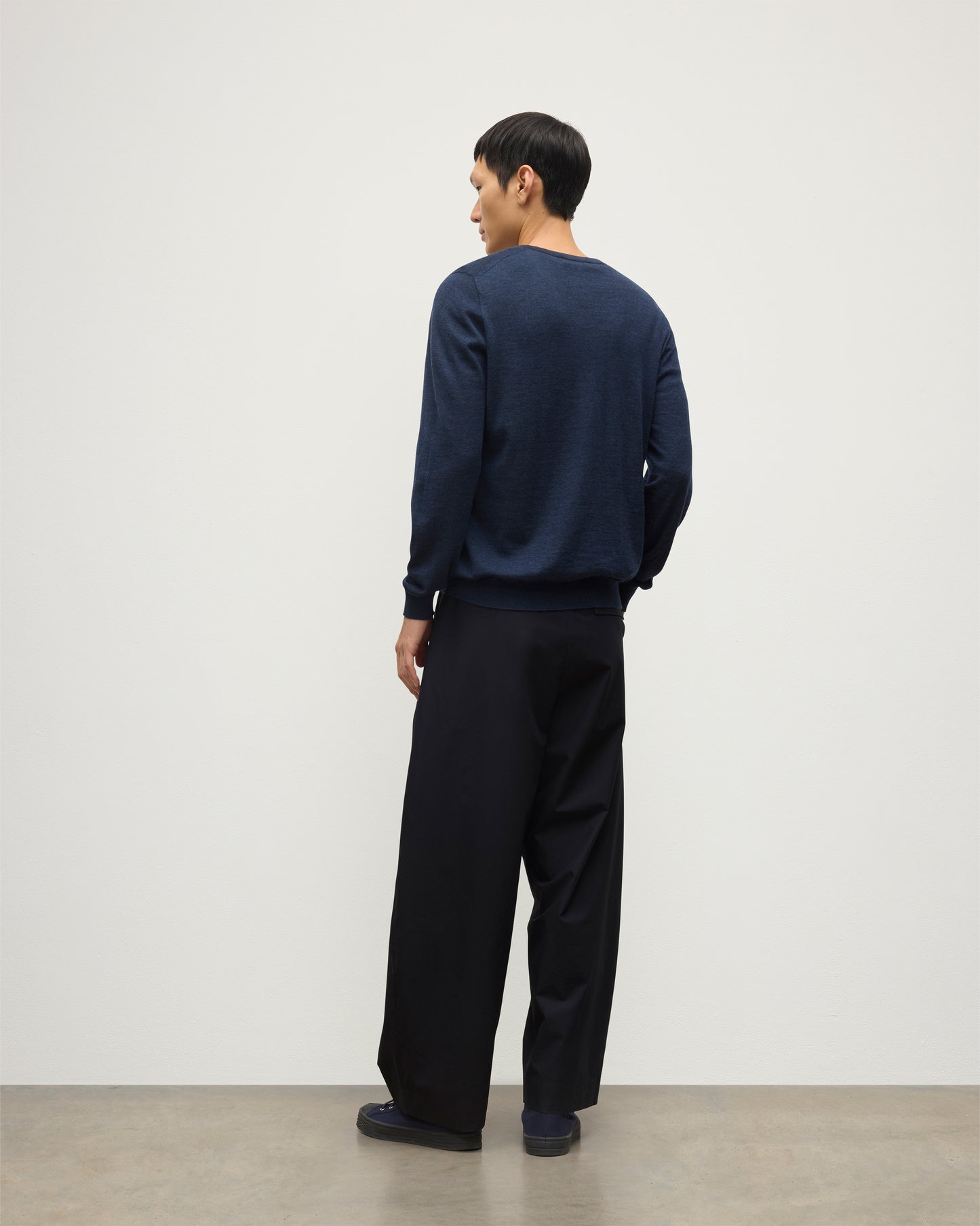 MENS FIN SUPERFINE VEE NECK NAVY 100% SUPERFINE CASHMERE BY JOHNSTONS OF ELGIN, WORN OVER A WHITE T-SHIRT WITH NAVY TROUSERS KAI05744HD7350