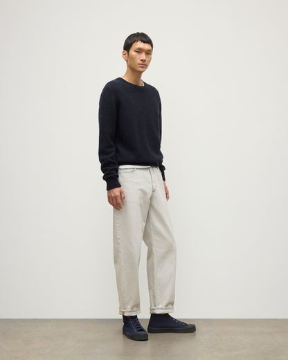 MODEL WEARS JOHNSTONS OF ELGIN  MENS TIREE CREW SWEATER BLUE 100% DONEGAL CASHMERE WITH WHITE JEANS KAI05755HD7348