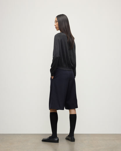 MODEL WEARING JOHNSTONS OF ELGIN WOMENS FINOLA SWEATER GREY 100% SUPERFINE CASHMERE  WITH BLACK LONG SHIRTS, SOCKS AND LOAFERS KAI05789HA7218