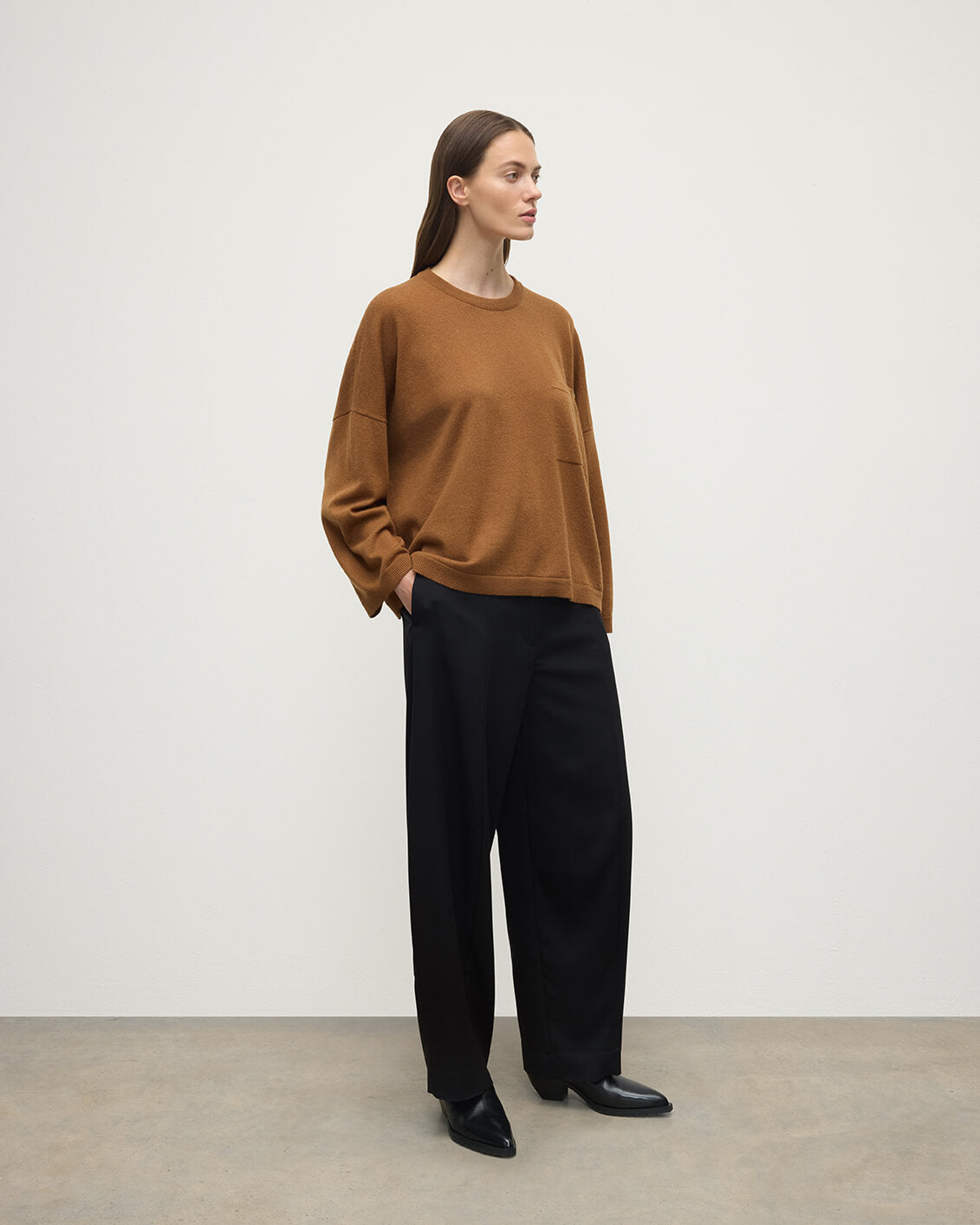 Model wears Johnstons of Elgin AW25 Women's Knitwear Dark Camel Gauzy Pocket Camel Cashmere Jumper Side View KAP05315SB4620