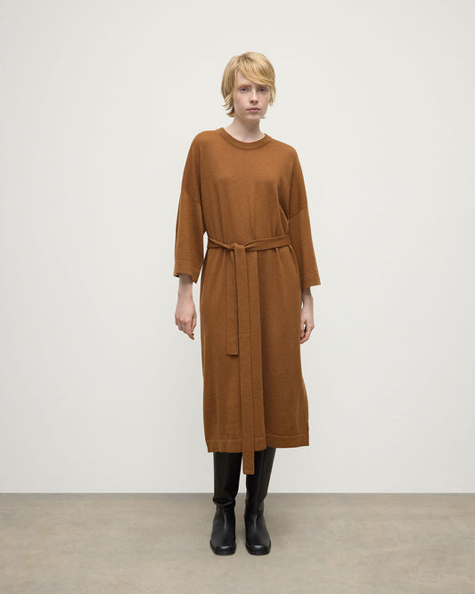 Model wears Johnstons of Elgin AW25 Women's Knitwear Dark Camel Tie-Waist Cashmere Camel Jumper Dress Front View  KAP05490SB4620