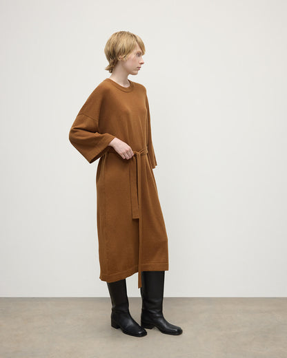 Model wears Johnstons of Elgin AW25 Women's Knitwear Dark Camel Tie-Waist Cashmere Camel Jumper Dress Side View  KAP05490SB4620