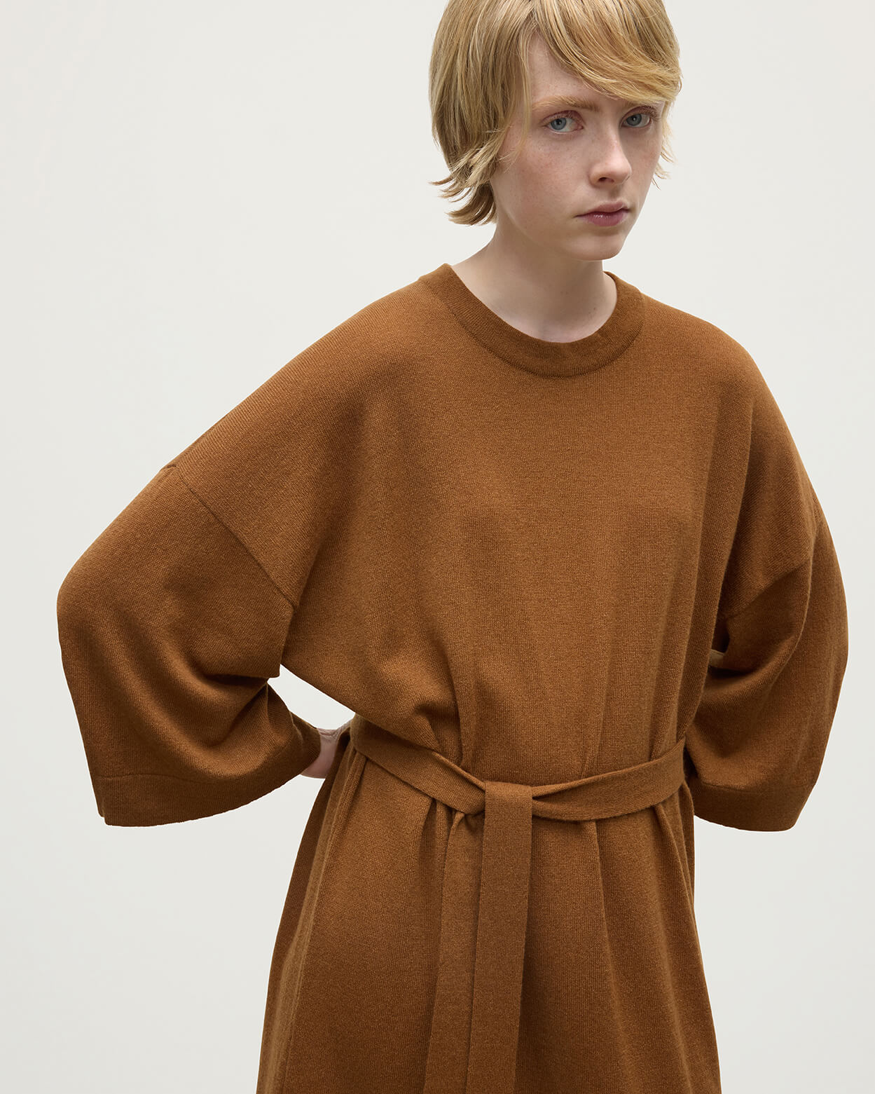 Model wears Johnstons of Elgin AW25 Women's Knitwear Dark Camel Tie-Waist Cashmere Camel Jumper Dress Details   KAP05490SB4620