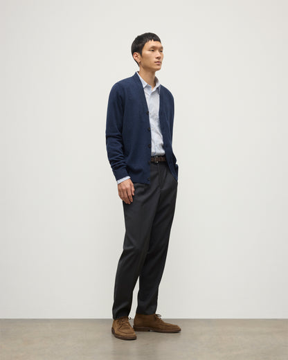 MODEL WEARS JOHNSTONS OF ELGIN MENS RORY VEE NECK CLASSIC CARDIGAN NAVY 100% CASHMERE OVER A LIGHT BLUE SHIRT WITH NAVY TROUSERS KAP05576HD7350