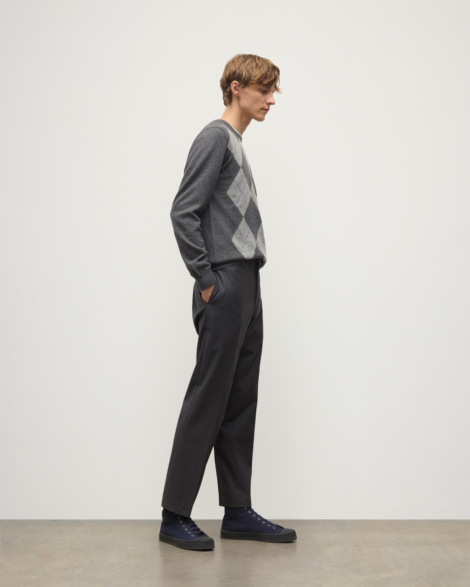 MODEL WEARS JOHNSTONS OF ELGIN MENS ARGYLL CREW SWEATER GREY & BROWN 100% CASHMERE WITH GREY TROUSERS KAP05747JU1601