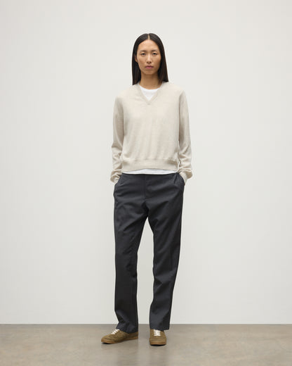 MODEL WEARING JOHNSTONS OF ELGIN WOMENS LUNAN CLASSIC VEE SWEATER NATURAL 100% CASHMERE WITH NAVY TROUSERS KAP05807HA0402