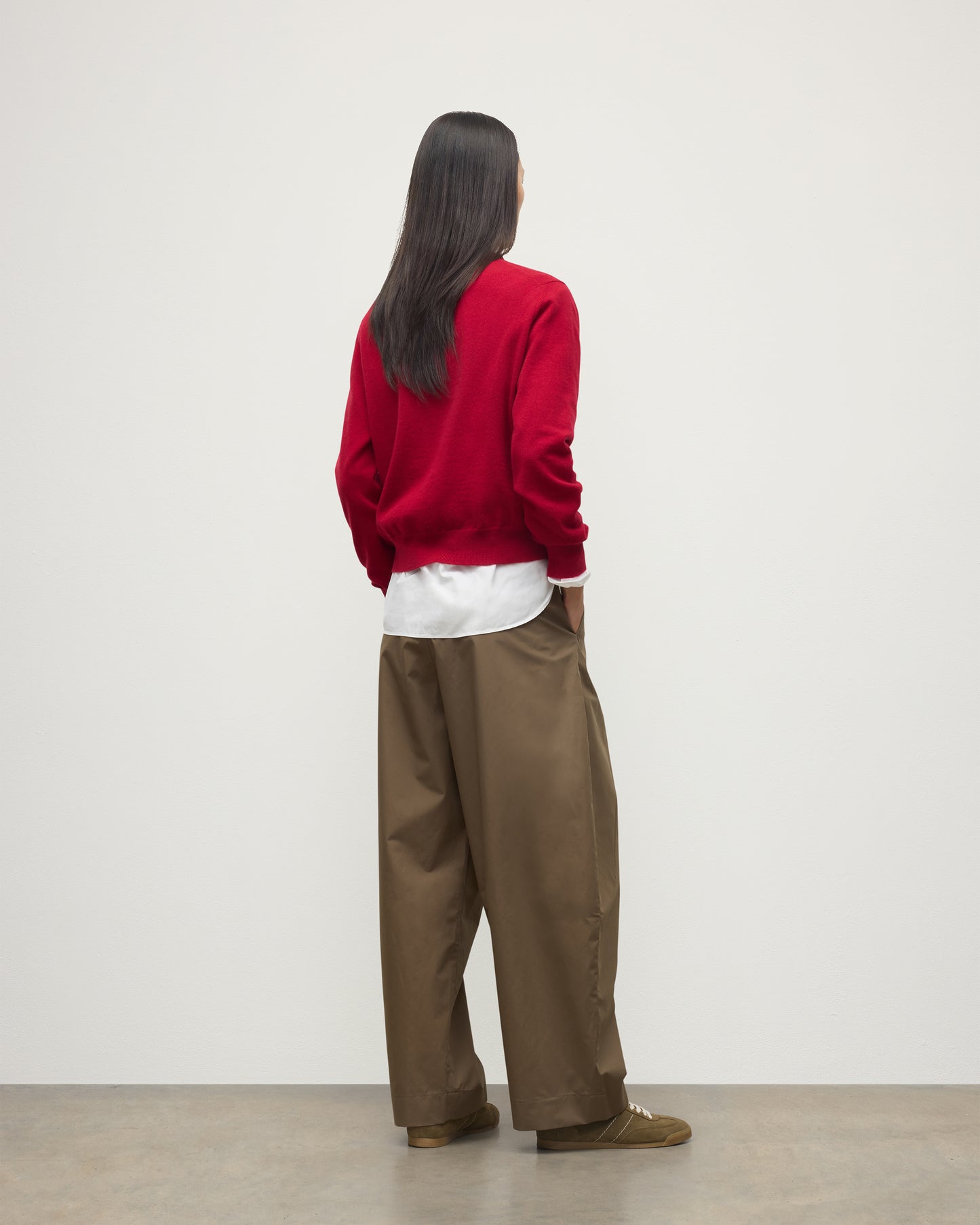 MODEL WEARING JOHNSTONS OF ELGIN WOMENS LUNAN CLASSIC VEE SWEATER RED 100% CASHMERE OVER WHITE SHIRT WITH BROWN TROUSERS KAP05807SE5325