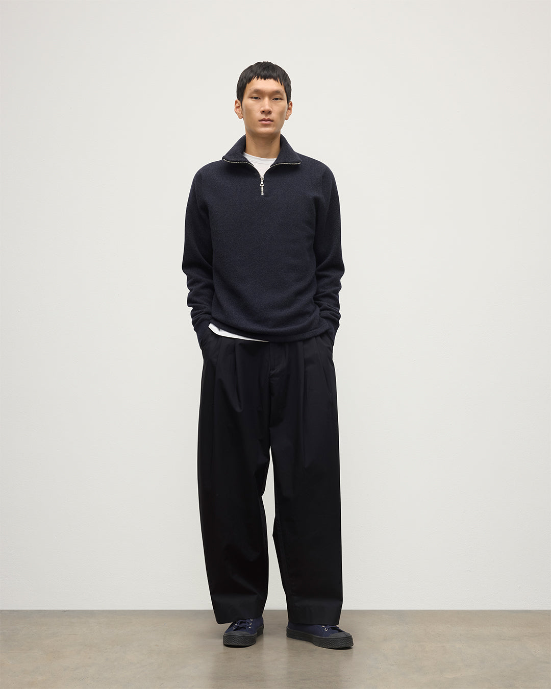 MODEL WEARS JOHNSTONS OF ELGIN MENS TWEEL HALF ZIP SWEATER NAVY & DARK GREY 100% CASHMERE OVER A WHITE T-SHIRT WITH NAVY TROUSERS KAP05832Q25934
