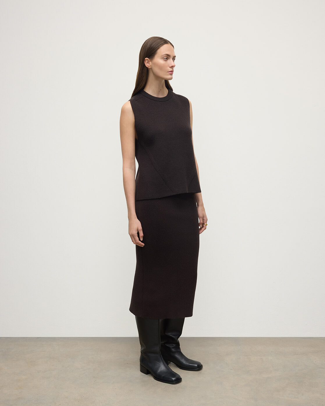 Model wears Johnstons of Elgin AW25 Women's Knitwear Molasses Cashmere Brown Midi Skirt KBC01032SB7290