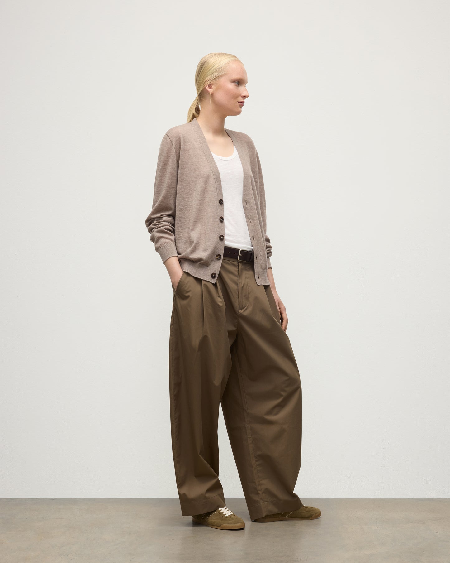FEMALE MODEL WEARING JOHNSTONS OF ELGIN FORSYTH SUPERFINE VEE NECK CARDIGAN LIGHT BROWN WITH BROWN WIDE LEG TROUSERS UAI05740HB0273