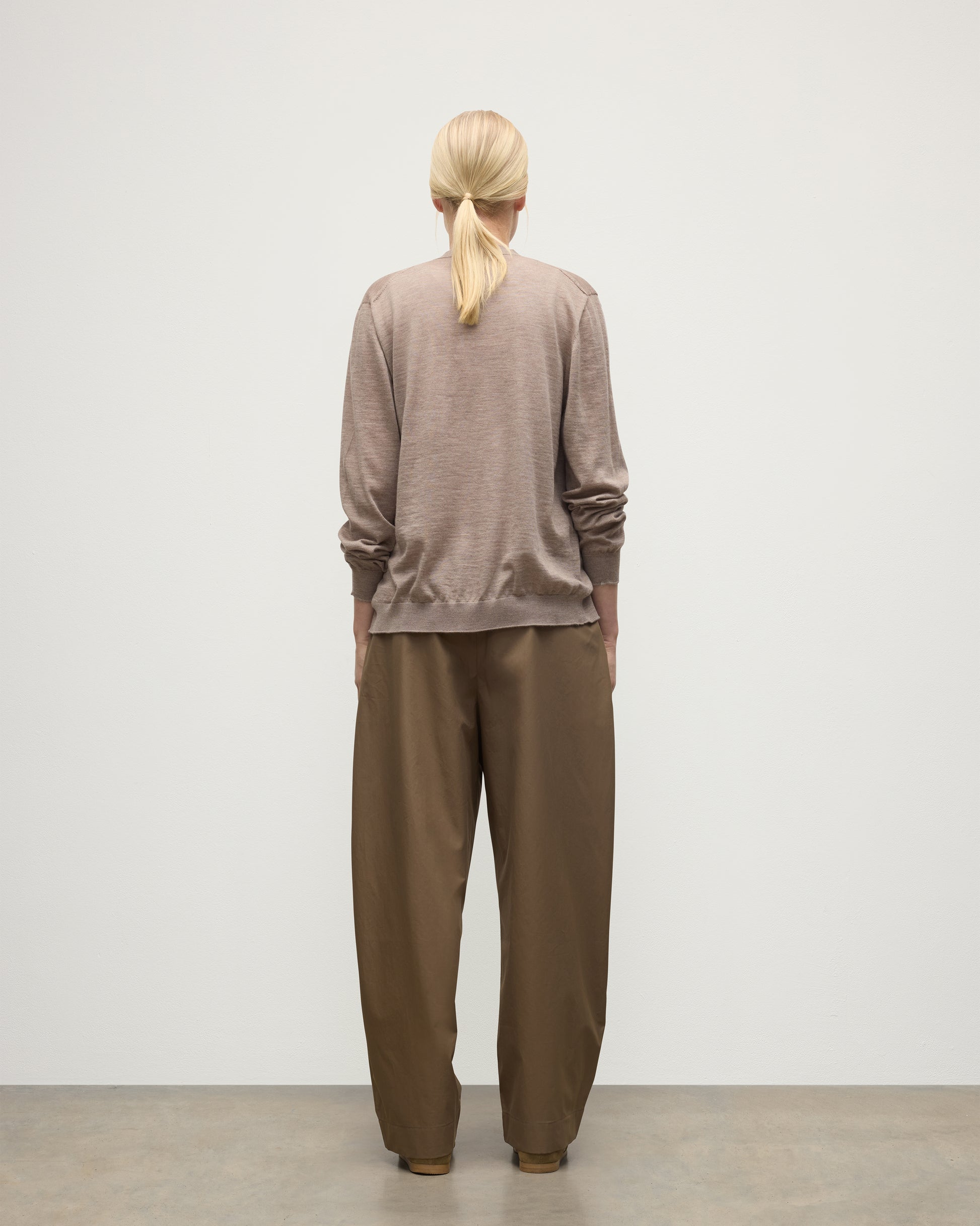 FEMALE MODEL WEARING JOHNSTONS OF ELGIN FORSYTH SUPERFINE VEE NECK CARDIGAN LIGHT BROWN WITH BROWN WIDE LEG TROUSERS UAI05740HB0273