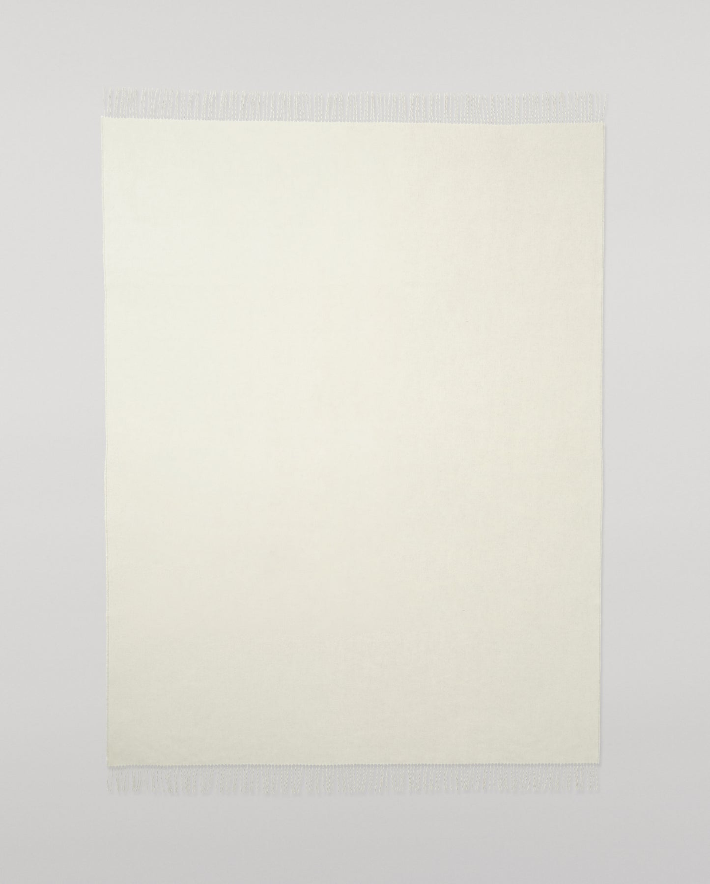 Johnstons of Elgin Light Grey & White reversible blanket on a grey background WA000013RU5059ONE